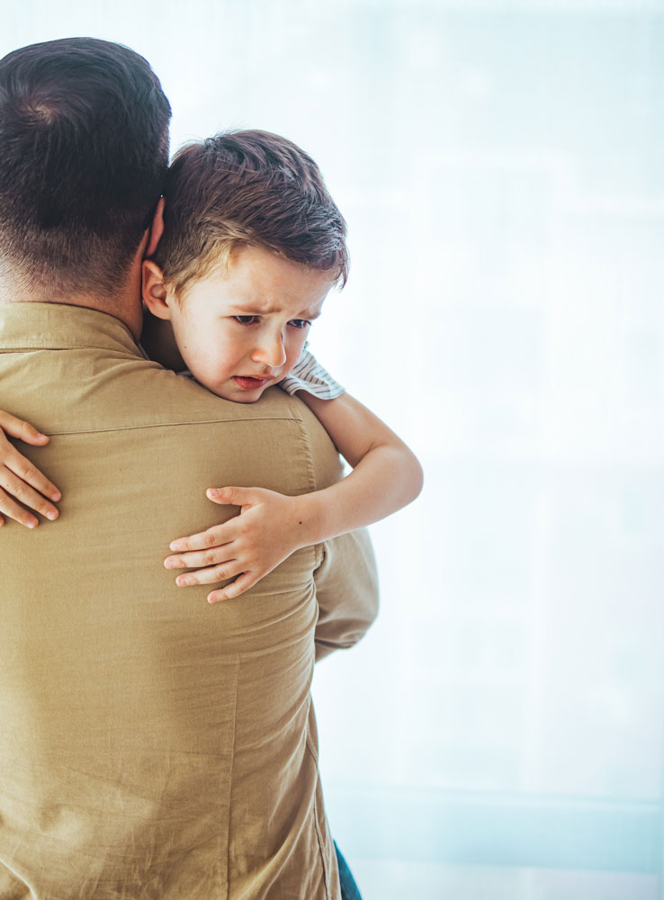 Padre con figlio triste in braccio